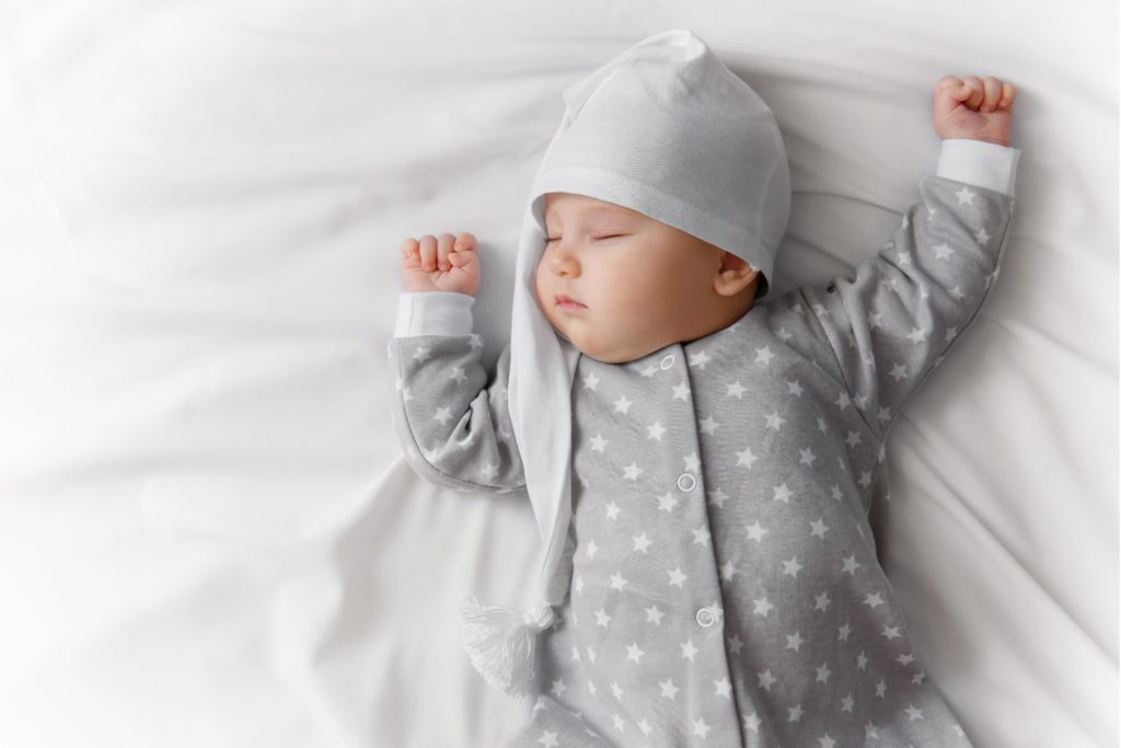 11 Monate altes Baby schläft in seinem Bettchen