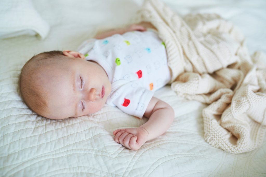 3 Monate altes Baby schläft in seinem Bettchen.