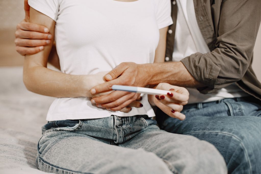 Paar mit Kinderwunsch hat Schwangerschaftstest in der Hand