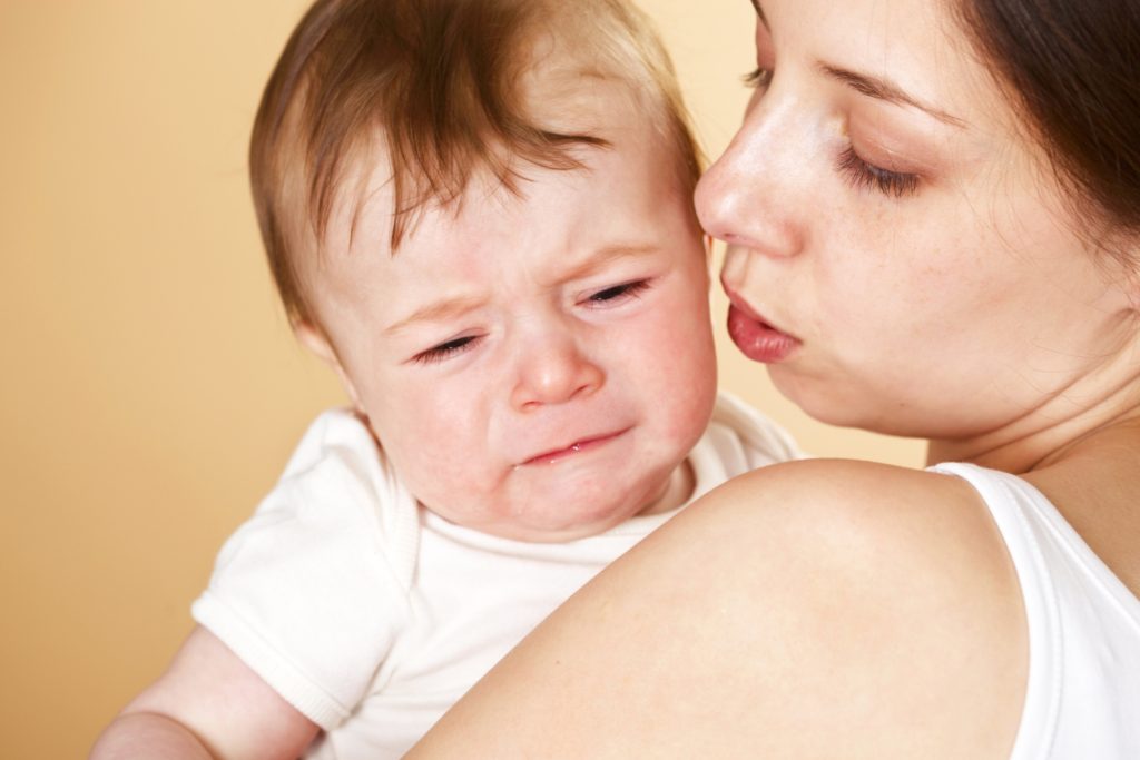 Mutter versucht, ihr weinendes 18 Monate altes Baby zu beruhigen.