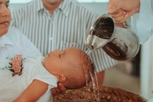 Baby wird sanft mit Wasser getauft