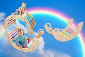 Ein Baby und ein Kleinkind spielen auf einer Regenbogenwippe.