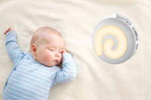 Ein Baby schläft neben einer Weisses Rauschen Soundmaschine.