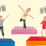 Drei Kleinkinder springen auf ihren Hüpfmatratzen im Kinderzimmer herum.